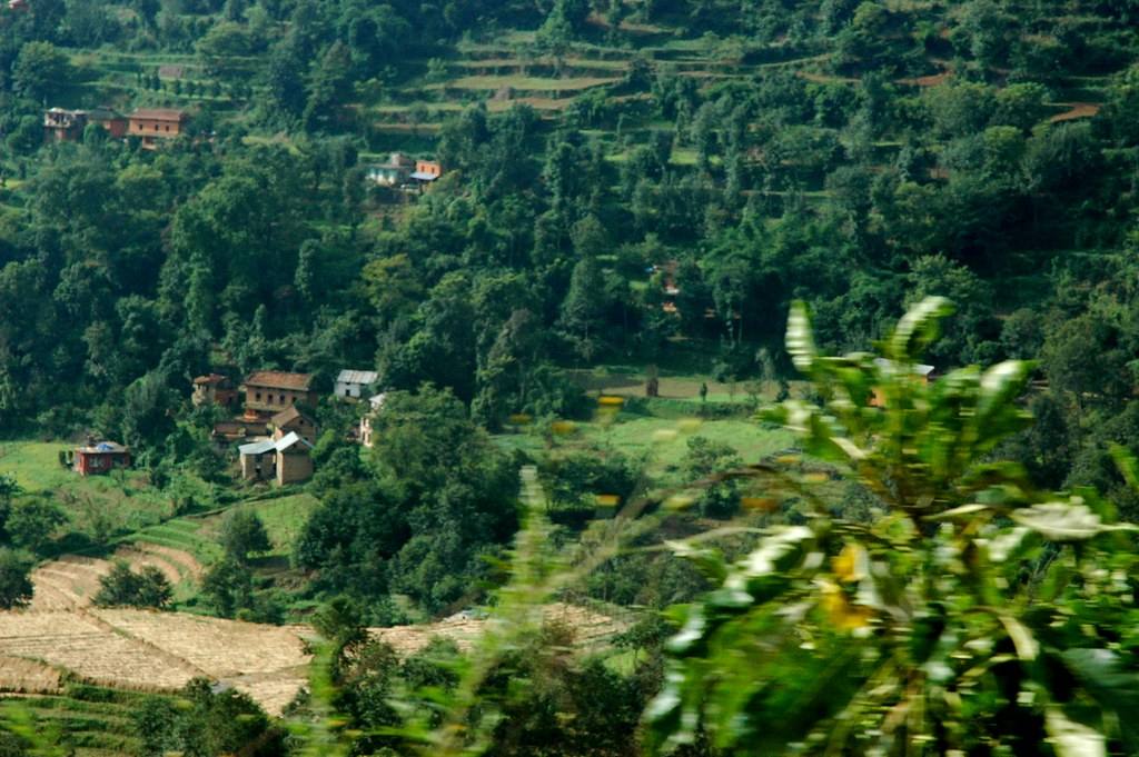 Village in the valley below, terraced fields, Himalayas, traveling to Pharping, on the paved road looking at rural Nepal